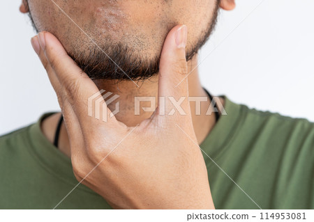 Cropped shot of Asian man touching his beard grows on a part of his lower face. Beard can make you feel more attractive. Cropped shot of Asian man touching his beard grows on a part of his lower face. Beard can make you feel more attractive. 114953081