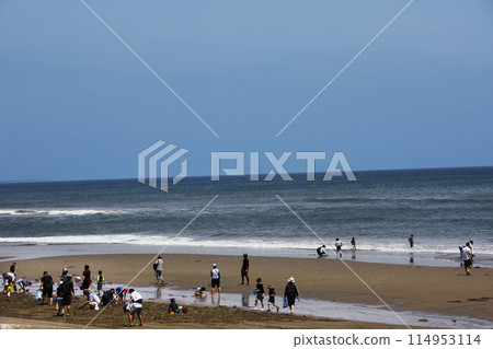 黃金周期間捕捉蛤蜊。天很藍,海浪很白,很多人在沙灘上快樂玩耍。 黃金周期間捕捉蛤蜊。天很藍,海浪很白,很多人在沙灘上快樂玩耍。 114953114