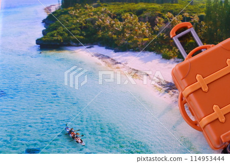 Image of traveling to a beach resort overseas with a suitcase placed against the backdrop of a beautiful beach 114953444