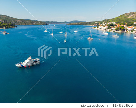 Scenic aerial view many yachts boats moored at Croatian bay harbor shore blue turquoise clear water at bright summer sunny day. Top above Mediterranean sea marina. Boat vessel charter service 114953969