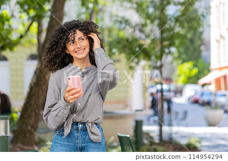 Caucasian young woman using smartphone typing text messages in social media application online Caucasian young woman using smartphone typing text messages in social media application online 114954294