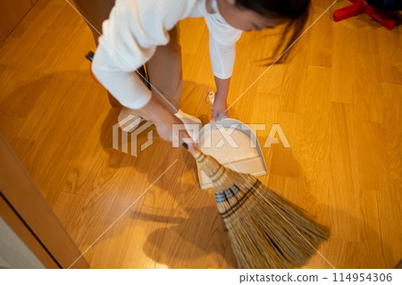 The house is swept clean with a broom and dustpan. 114954306
