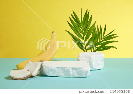 Banana and coconut products advertising template on yellow background, a blank plaster showcase pedestal placed in center of green table for displaying product. Frontal shot, space for text 114955308
