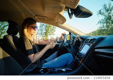 Woman Using Smartphone While Driving in a Car Woman Using Smartphone While Driving in a Car 114955856