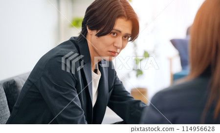Men sitting on sofa and talking 114956628