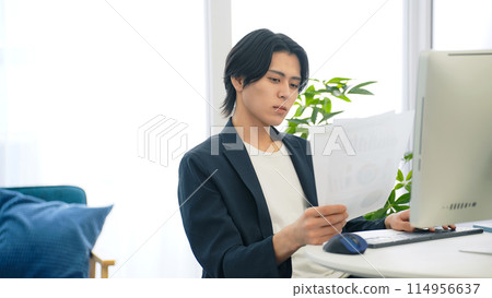 Man looking at documents in office Man looking at documents in office 114956637
