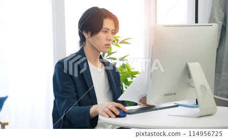 Man looking at documents in office 114956725
