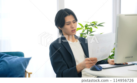 Man looking at documents in office 114956726