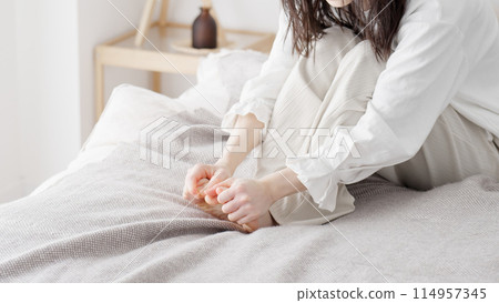 Woman rubbing cold feet Woman rubbing cold feet 114957345