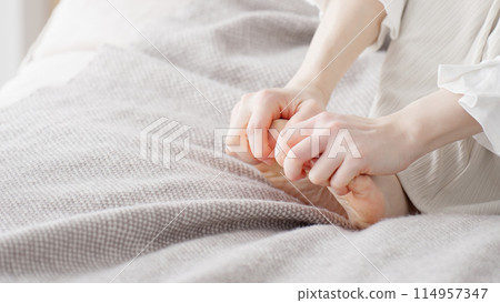 Woman rubbing cold feet 114957347