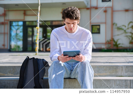 Young guy college student using digital tablet outdoor 114957950