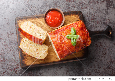 Healthy and comforting meal chicken meatloaf served with ketchup closeup on the wooden board. Horizontal top view Healthy and comforting meal chicken meatloaf served with ketchup closeup on the wooden board. Horizontal top view 114959039