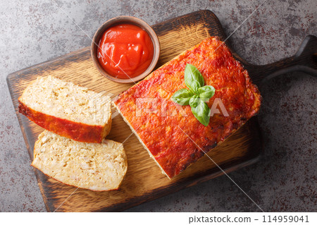 Sliced chicken meatloaf served with ketchup closeup on the wooden board. Horizontal top view 114959041