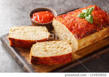 Sliced chicken meatloaf served with ketchup closeup on the wooden board. Horizontal Sliced chicken meatloaf served with ketchup closeup on the wooden board. Horizontal 114959050
