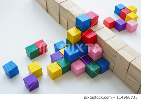 Colored cubes overcome an obstacle in the form of a wall. Creativity or diversity and inclusion concept. Colored cubes overcome an obstacle in the form of a wall. Creativity or diversity and inclusion concept. 114960735