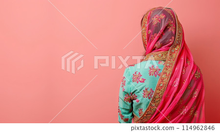 Traditional Indian women's costume dress on a pink background, copy space 114962846