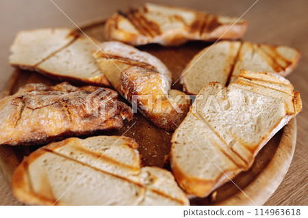 dried wheat bread, croutons, pieces, on a wooden round board dried wheat bread, croutons, pieces, on a wooden round board 114963618