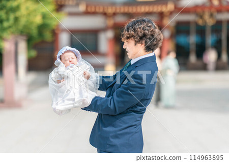 Father and son rejoice as they hold their son in their arms at a shrine visit Father and son rejoice as they hold their son in their arms at a shrine visit 114963895