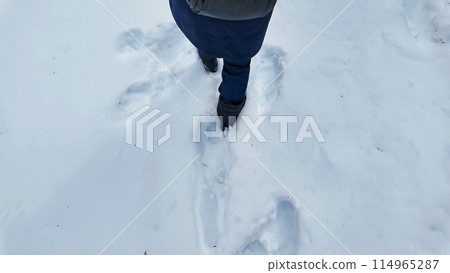 一個女人的腳在雪地上行走 114965287