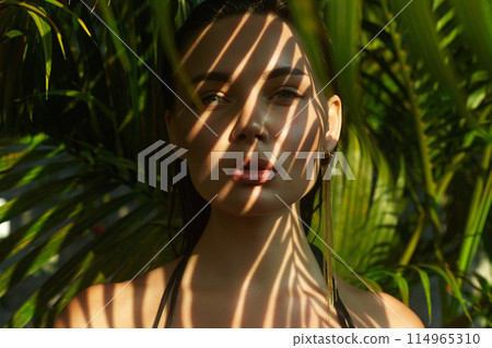 beautiful summer girl. young sexy woman in bikini under palm tree 114965310