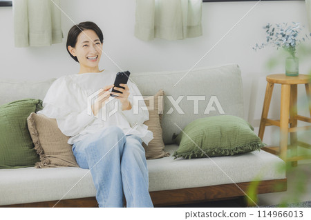 A woman watching a smartphone A woman watching a smartphone 114966013
