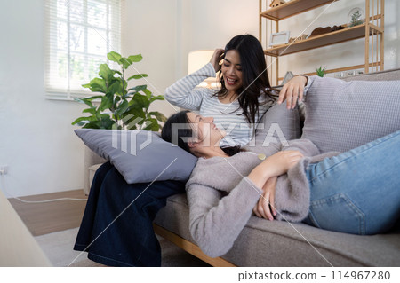 Asian lesbian couple relaxing on sofa at home. Concept of love and companionship 114967280