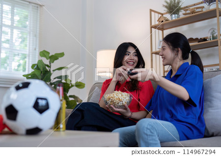 Asian lesbian couple watching Euro football match at home. Concept of cheer and football 114967294