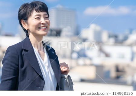 A middle-aged female manager working in the city A middle-aged female manager working in the city 114968150