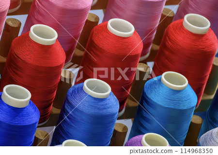 Close up the multi-color group of industry bobbin thread. Close up the multi-color group of industry bobbin thread. 114968350