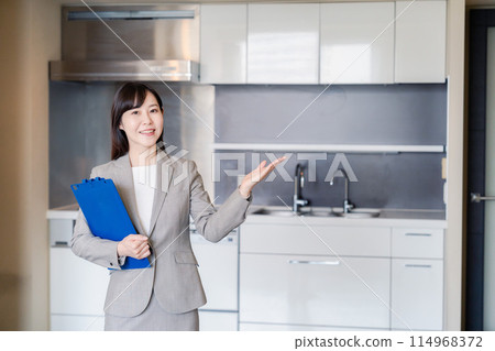 A woman from a real estate agency showing a property 114968372