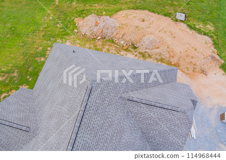 In course of building new house, construction roof is being covered with rubber asphalt roof shingles 114968444