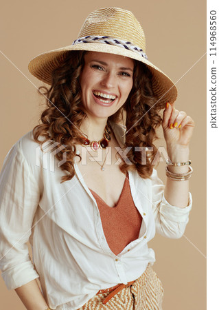 happy housewife in blouse and shorts against beige 114968560