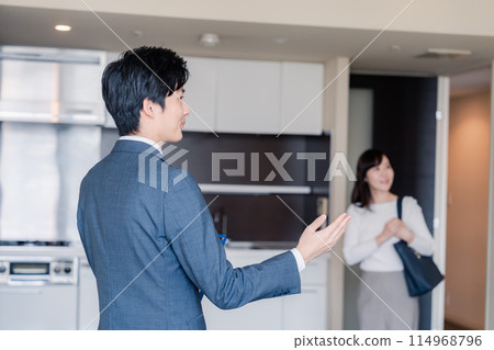 A man from a real estate agency showing around an apartment building 114968796