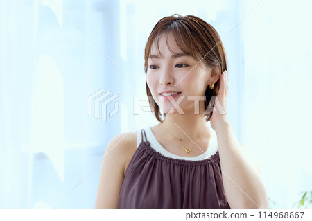 一個女人透過蕾絲窗簾在房間裡放鬆 一個女人透過蕾絲窗簾在房間裡放鬆 114968867