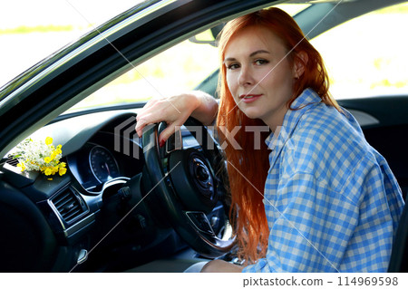 A girl poses for the camera with her car in nature. Joy, happiness, serenity. A girl with a car in nature. 114969598