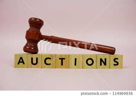 Auctions alphabet letters with wooden blocks alphabet letters and Gavel on pink background Auctions alphabet letters with wooden blocks alphabet letters and Gavel on pink background 114969836