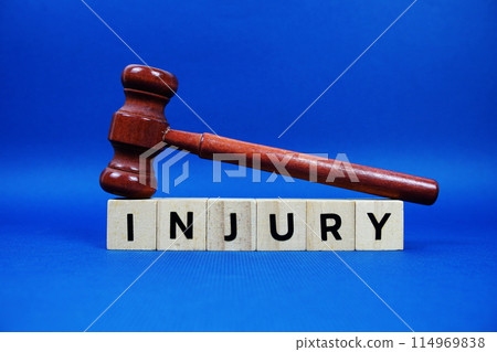 Injury alphabet letters with wooden blocks alphabet letters and Gavel on blue background 114969838
