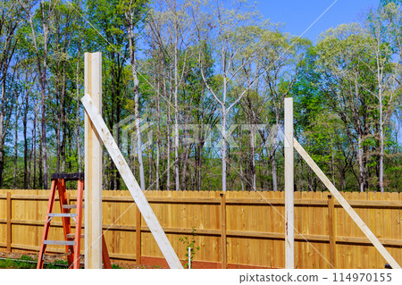 In area of construction new home, frame beams wooden house are still unfinished In area of construction new home, frame beams wooden house are still unfinished 114970155