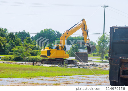 An excavator loads construction waste concrete into dump container An excavator loads construction waste concrete into dump container 114970156