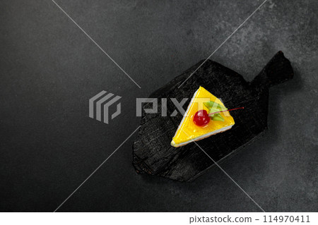 Lemon cheesecake with cherry. On a black background 114970411