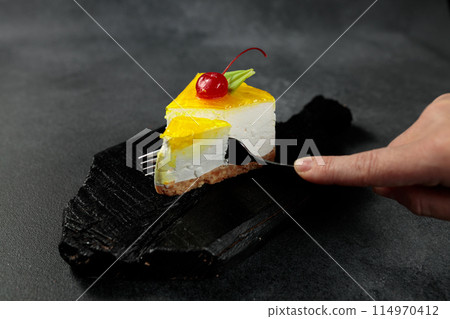 Lemon cheesecake with cherry. On a black background 114970412
