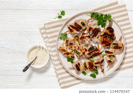 grilled mini pork skewers on a plate, top view grilled mini pork skewers on a plate, top view 114970547