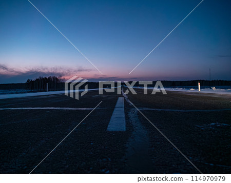 Empty rural road at twilight in winter with clearing skies Empty rural road at twilight in winter with clearing skies 114970979