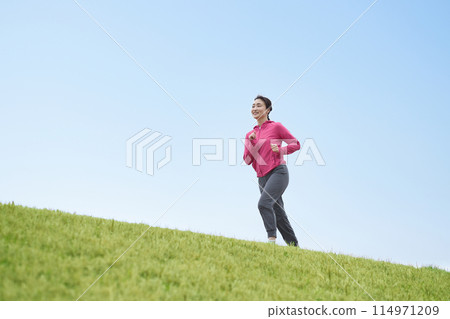 Middle-aged woman running in sportswear 114971209