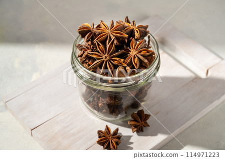 Star anise spice in a wooden bowl on bright background Star anise spice in a wooden bowl on bright background 114971223