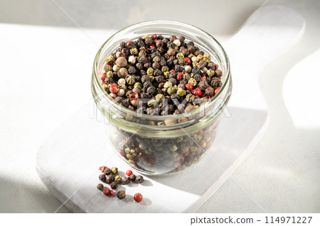 Mixed pepper corn. Black, red and white peppercorns in a glass jar. Mixed pepper corn. Black, red and white peppercorns in a glass jar. 114971227
