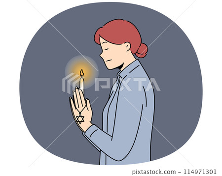 Praying jewish woman with burning candle in hand for international holocaust remembrance day concept 114971301