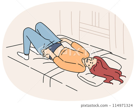 Overweight woman tries in vain to put on small pants lying on bed in bedroom of apartment 114971324