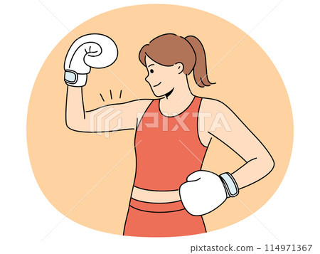 Woman boxer shows biceps and smiles demonstrating strength and determination to defeat opponent 114971367
