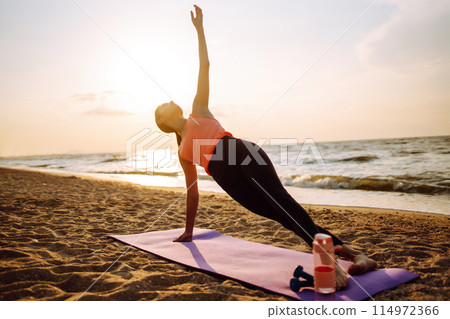 Young woman in sportswear doing yoga, fitness exerciseon the beach. Sport, Active life. Young woman in sportswear doing yoga, fitness exerciseon the beach. Sport, Active life. 114972366